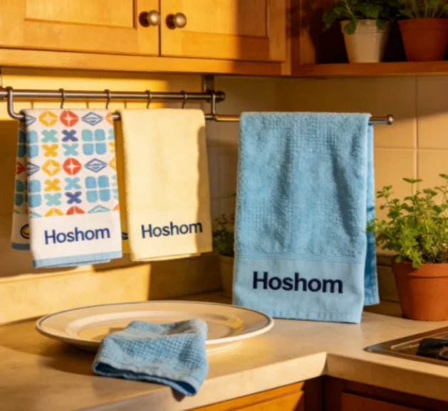 A set of personalized tea towels with the brand name "Hoshom" displayed in a kitchen setting